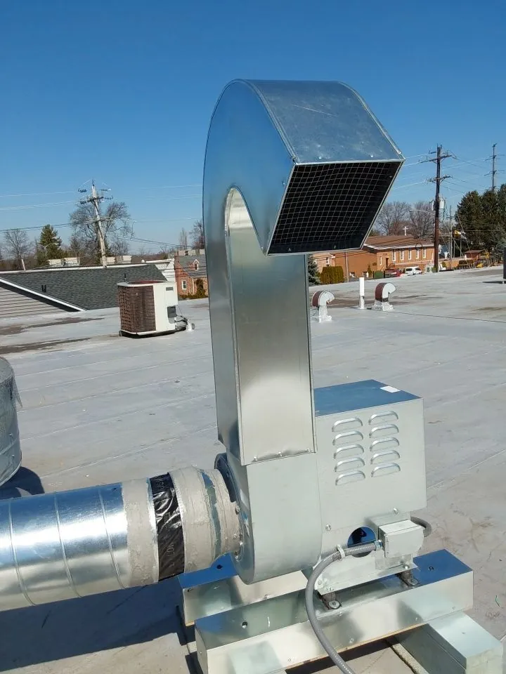Rooftop exhaust fan and duct connection on a commercial roof