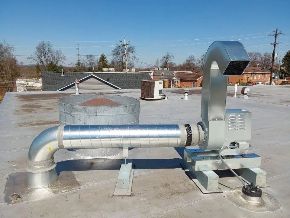 Rooftop exhaust fan connected to sheet-metal ductwork