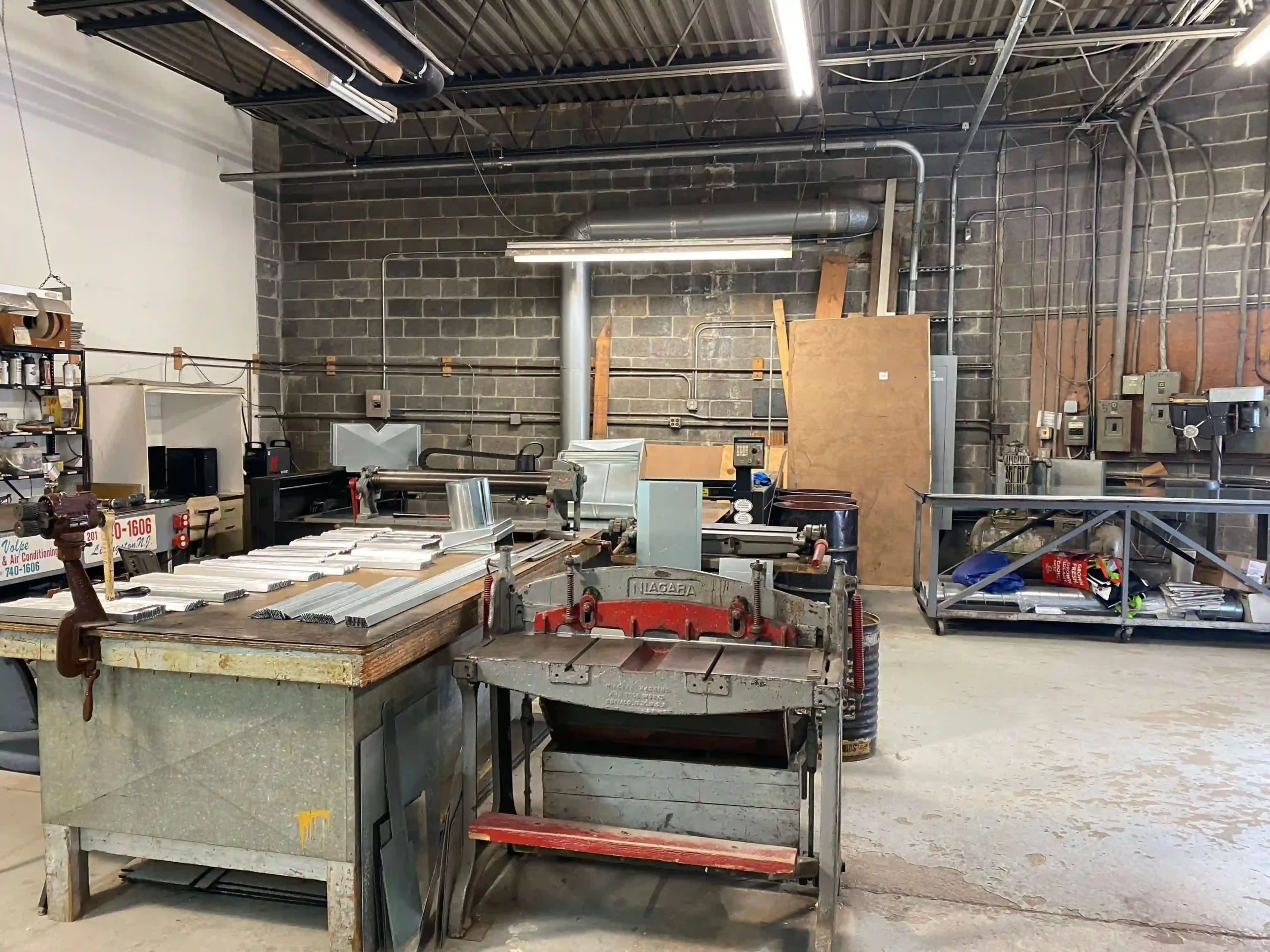 Volpe sheet-metal shop with fabrication tables and ductwork materials