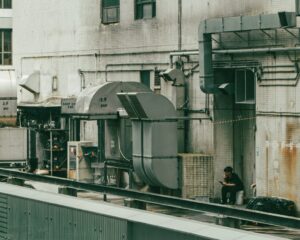 HVAC technician inspecting a residential unit outdoors in a suburban neighborhood